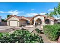 Inviting single-story home boasting a terra cotta roof, two-car garage, and lush front yard landscaping at 322 E Gary Cir, Mesa, AZ 85201