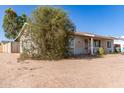 Side view of a cozy single-story home featuring desert landscaping, offering a peaceful and private setting at 3256 W Libby St, Phoenix, AZ 85053