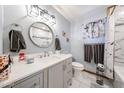 Stylish bathroom features modern fixtures, a round mirror, and a marble-tiled shower at 3848 W Kings Ave, Phoenix, AZ 85053
