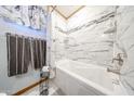 A bathtub with marble-like tile surround, with a shower head at 3848 W Kings Ave, Phoenix, AZ 85053
