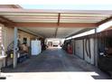 Spacious carport featuring a metal awning covering a long driveway, suitable for multiple vehicles at 3848 W Kings Ave, Phoenix, AZ 85053