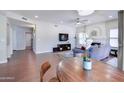 Open-concept living room with a fireplace, flat-screen TV, and wood flooring at 3921 W Jasper Dr, Chandler, AZ 85226