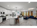 Open-concept kitchen and living room featuring modern appliances, a large island, and stylish decor at 435 E Shellie Ct, Casa Grande, AZ 85122
