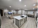 Bright, open-concept living room and kitchen with modern finishes, an island, and an attached dining area at 5490 W Trenton Way, Florence, AZ 85132