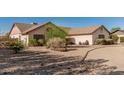 Beige single-story house showcasing desert landscaping, foliage, and a driveway at 6032 W Grovers Ave, Glendale, AZ 85308