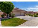 Charming single-Gathering home featuring a well-maintained lawn and a spacious driveway leading to a three-car garage at 7231 W Lone Cactus Dr, Glendale, AZ 85308