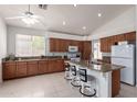 Well-lit kitchen with granite countertops, a large island with bar stools, and plenty of cabinet space at 7231 W Lone Cactus Dr, Glendale, AZ 85308