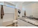 Well-lit bathroom with granite countertops, white cabinets, and a combined shower and tub at 8048 E Paloma Ave, Mesa, AZ 85212
