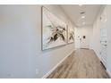 Bright hallway with wood-look tile flooring, contemporary art, and access to various rooms at 8048 E Paloma Ave, Mesa, AZ 85212