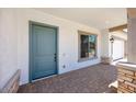 Inviting front porch with brick pavers and a blue front door, offering a welcoming entrance to the home at 8318 W Palo Verde Dr, Glendale, AZ 85305