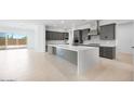 Modern kitchen with gray cabinets, a large island, stainless steel appliances, and tile flooring throughout at 8318 W Palo Verde Dr, Glendale, AZ 85305