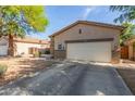 Lovely home exterior with a two-car garage, desert landscaping, and lush trees surrounding the property at 839 E Leo Pl, Chandler, AZ 85249