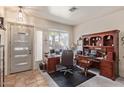 This home office is naturally lit with windows and includes a door for privacy and a traditional executive desk at 839 E Leo Pl, Chandler, AZ 85249