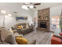 Comfortable living room with stone fireplace, neutral palette, and access to outdoor patio at 9125 E Gelding Dr, Scottsdale, AZ 85260