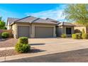 Attractive single-story home featuring a three-car garage and desert landscaping at 9532 E Knoll Cir, Mesa, AZ 85207