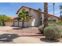 The beautiful home has a three-car garage and desert landscaping, creating an inviting curb appeal at 987 E Divot Dr, Tempe, AZ 85283
