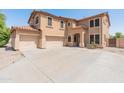 Beige two-story home featuring a spacious driveway and attached three-car garage at 15985 W Bartlett Ave, Goodyear, AZ 85338