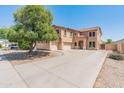 Two-story home with beige stucco, tile roof, and spacious driveway at 15985 W Bartlett Ave, Goodyear, AZ 85338