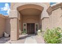 Elegant front entryway featuring double doors, textured pillars, desert landscaping, and a welcoming walkway at 16436 S 1St Ave, Phoenix, AZ 85045