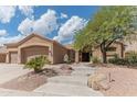 Inviting exterior with a two-car garage, desert landscaping, stone accents, and a charming entryway with steps at 16436 S 1St Ave, Phoenix, AZ 85045