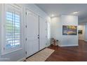 Bright foyer with double doors, white trim, hardwood floors, and a view into the hallway at 16436 S 1St Ave, Phoenix, AZ 85045