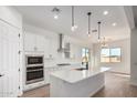 Modern kitchen with white cabinetry, stainless steel appliances, an island with a sink, and ample natural light at 16455 W Avenida Del Sol --, Surprise, AZ 85387
