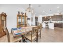 Open concept dining room with a wooden table, chandelier, and direct access to the kitchen at 17003 W Alameda Rd, Surprise, AZ 85387