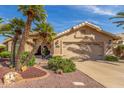Tan single-story home with manicured desert landscaping and a two-car garage at 17543 N Rainbow Cir, Surprise, AZ 85374