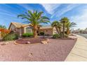 Desert landscaping and mature palm trees accent this beautiful tan single-story home at 17543 N Rainbow Cir, Surprise, AZ 85374
