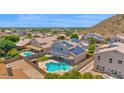 Aerial view of home with solar panels on roof and a sparkling in-ground swimming pool in the backyard at 1755 N 74 Th Pl, Mesa, AZ 85207