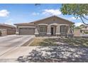 Inviting single-story home featuring desert landscaping, a two-car garage, and shaded front porch at 18998 E Lark Dr, Queen Creek, AZ 85142