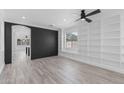 Bright living room boasts luxury vinyl plank flooring, built-in shelves, and a modern ceiling fan at 18998 E Lark Dr, Queen Creek, AZ 85142