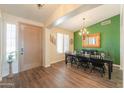 Elegant dining room featuring wood floors, chandelier, and decorative green accent wall at 2041 E Palm Beach Dr, Chandler, AZ 85249