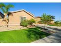 Desert home featuring manicured lawn, mature trees and desert landscaping, and inviting curb appeal at 24645 N 65Th Ave, Glendale, AZ 85310