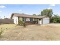 Well-maintained single-story home featuring a two-car garage, brick accents, and a spacious front yard in a suburban neighborhood at 2633 E Garnet Ave, Mesa, AZ 85204