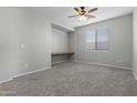 Bright bedroom with neutral walls, built-in desk and ceiling fan at 29302 N 126Th Ln, Peoria, AZ 85383