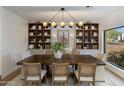This dining room features custom built-ins, stylish lighting, and backyard views at 3186 E Stella Ln, Phoenix, AZ 85016