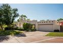 Southwestern home showing desert landscaping, brick driveway, garage and a stucco exterior at 3186 E Stella Ln, Phoenix, AZ 85016