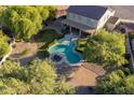 Aerial view of a backyard with a lagoon-style pool, mature trees, and ample seating at 32311 N Cat Hills Ave, San Tan Valley, AZ 85144
