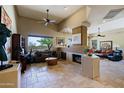 Spacious living room featuring high ceilings, tile flooring, a fireplace, and large windows at 32516 N 68Th Pl, Scottsdale, AZ 85266