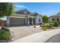 Attractive home featuring a brick-paved driveway and lush landscaping, with a convenient two-car garage at 41465 W Sussex Dr, Maricopa, AZ 85138