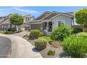 Lovely single-story home with well-manicured landscaping, a two-car garage, and a brick driveway at 41465 W Sussex Dr, Maricopa, AZ 85138