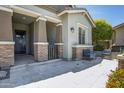 Inviting front porch with stylish tiled flooring, brick pillars and a cozy seating area at 41465 W Sussex Dr, Maricopa, AZ 85138