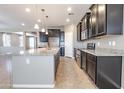 A kitchen showcasing an island, granite countertops, and dark wood cabinets at 4277 N 180Th Ln, Goodyear, AZ 85395