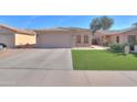 Charming single-story home featuring a two-car garage and well-maintained artificial lawn at 43935 W Sagebrush Trl, Maricopa, AZ 85138