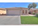 Charming single-story home featuring a two-car garage and well-maintained artificial lawn at 43935 W Sagebrush Trl, Maricopa, AZ 85138