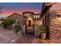 Stunning home featuring stone accents, a gated courtyard, and desert landscaping at 9753 E Suncrest Rd, Scottsdale, AZ 85262