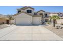 Expansive driveway and three-car garage in this two-story house with desert landscaping at 1031 W Longhorn Dr, Chandler, AZ 85286