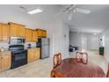 Bright kitchen with tile flooring, stainless steel refrigerator, and wood cabinetry at 10334 E Diamond Ave, Mesa, AZ 85208