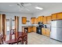 Eat-in kitchen with wood cabinets, black appliances, and access to the backyard at 10334 E Diamond Ave, Mesa, AZ 85208